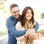 A happy couple enjoying an outdoor engagement photoshoot with laughter and love.